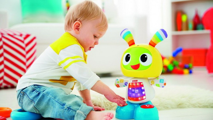 Мальчик до 3 лет забавляется с игрушечныи роботом