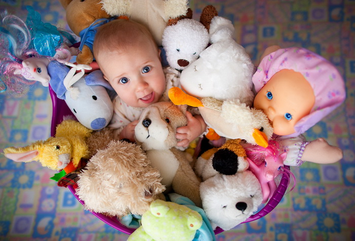 Ребенок в окружении безопасных мягких игрушек